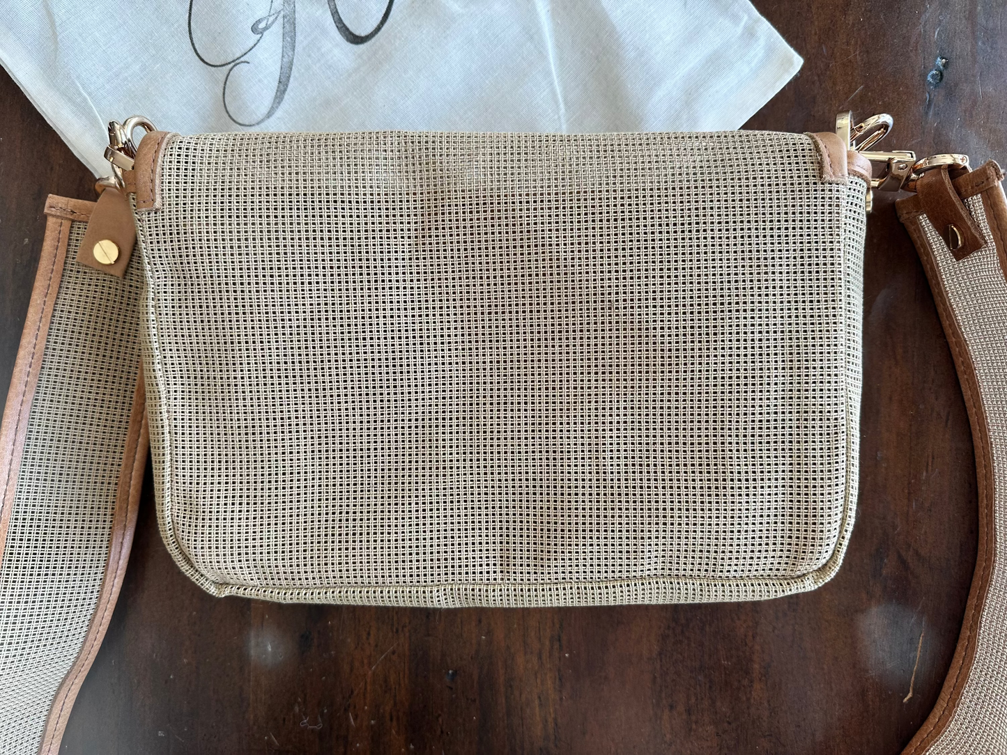 Textured pouch with brown leather accents on a wooden surface